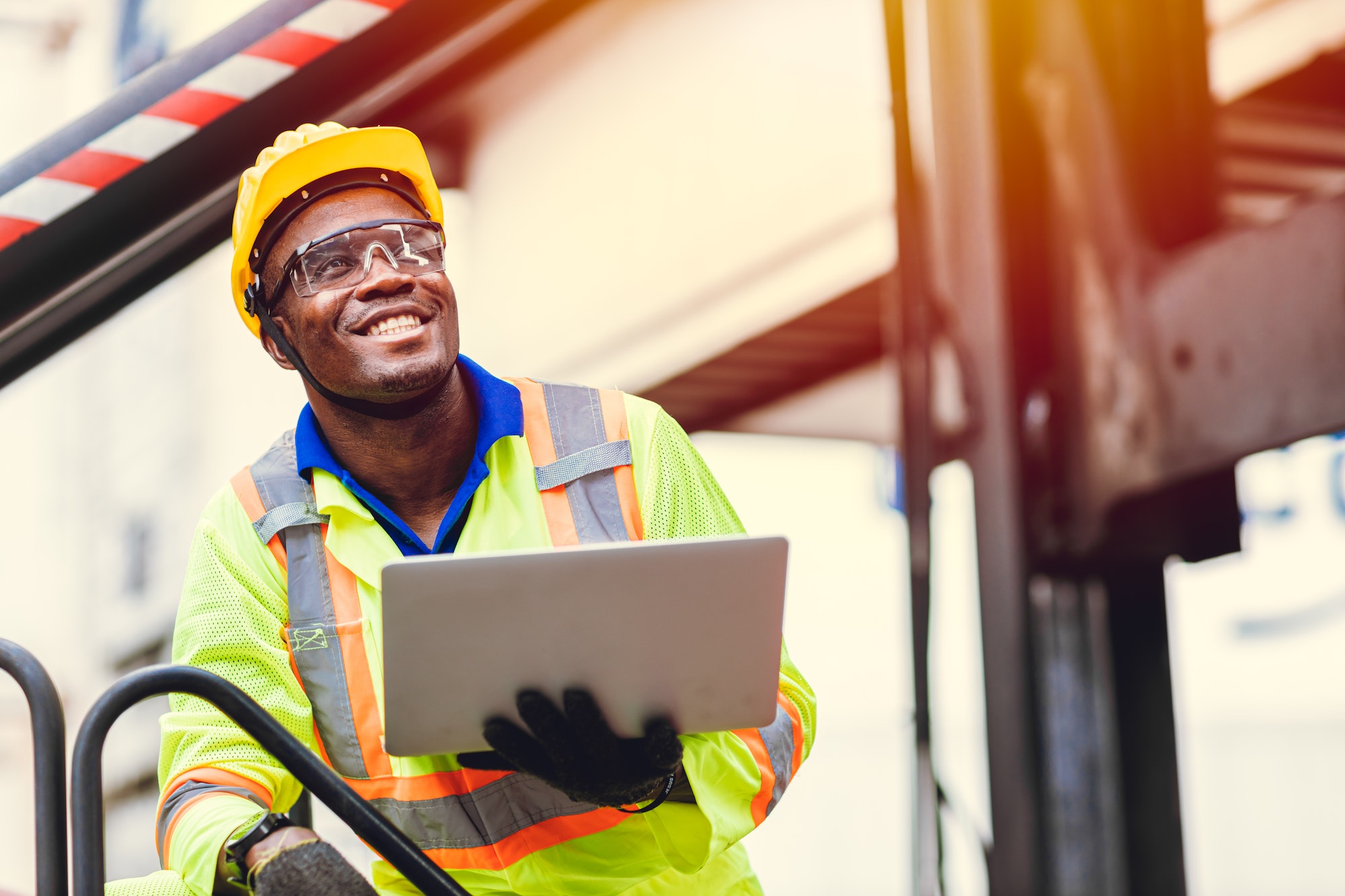 Black African happy worker working in logistic shipping with laptop computer control loading smile